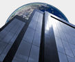 Picture looking upwards across face of building to see moon above